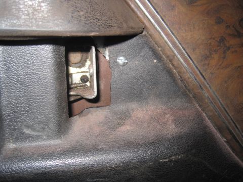 1979 Ford Bronco - Detail of a vehicle's interior door panel, revealing a mechanical latch and surrounding trim.