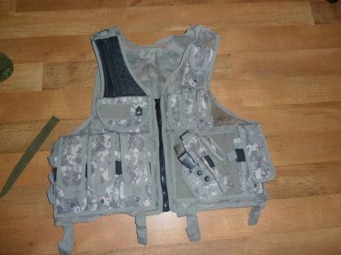 1992 Ford Mustang - A digital camouflage tactical vest with various pouches and a holster is laid out on a wooden surface.