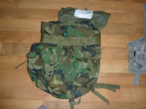 1992 Ford Mustang - A camouflage military backpack is shown from a top-down perspective on a wooden surface.