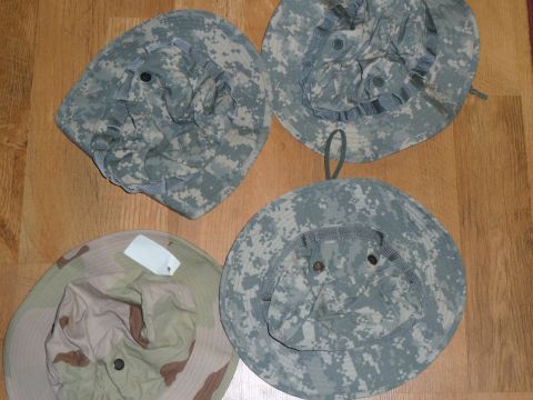 1992 Ford Mustang - A collection of four boonie hats, including three in digital woodland camouflage and one in desert camouflage, laid out on a wooden surface.