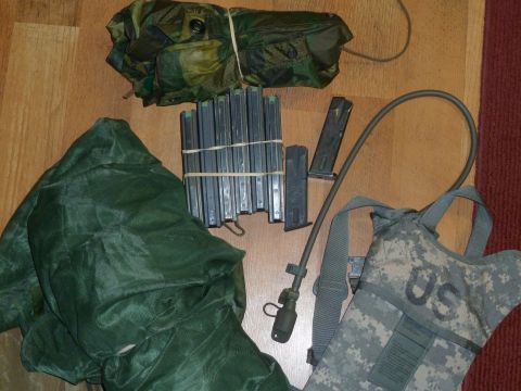 1992 Ford Mustang - Various military items, including a hydration pack and rifle magazines, are arranged on a wooden floor.