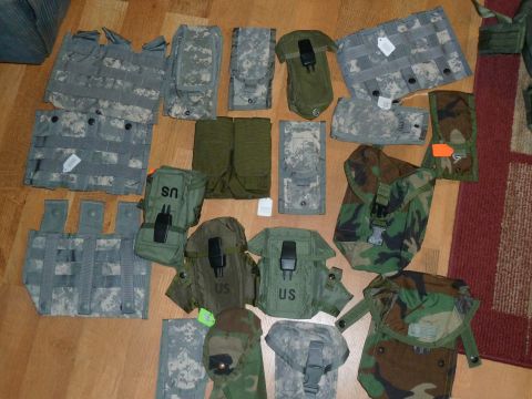 1992 Ford Mustang - A collection of military pouches and vests, some marked with 'US', are laid out on a wooden floor.