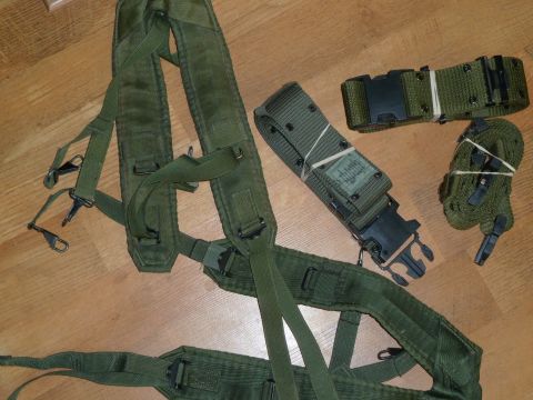 1992 Ford Mustang - Military gear including suspenders and a belt, shown on a wooden surface.