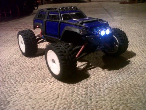 2011 Ford 427 - A blue remote control monster truck with a roll cage and large tires is shown from a 3/4 front angle.