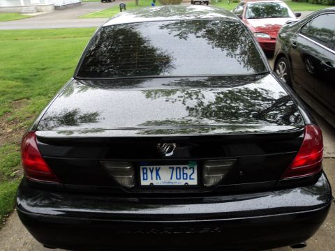 2004 Mercury Grand Marquis - Rear view of a black 2004 Mercury Grand Marquis sedan, showing its distinctive taillights and license plate.