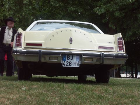 1977 Pontiac Trans Am - The rear of a cream-colored Lincoln Continental Mark V is visible, a spare tire cover and a French license plate.