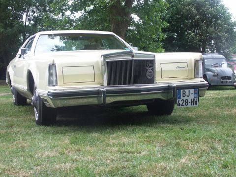 1977 Pontiac Trans Am - A Lincoln Continental Mark V is parked on a grassy lawn, with another vehicle visible in the background.