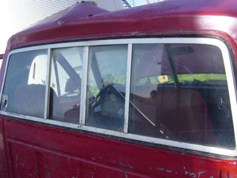 1992 Ford Bronco - The side of a red pickup truck cab is shown, with a view of the interior through the windows.