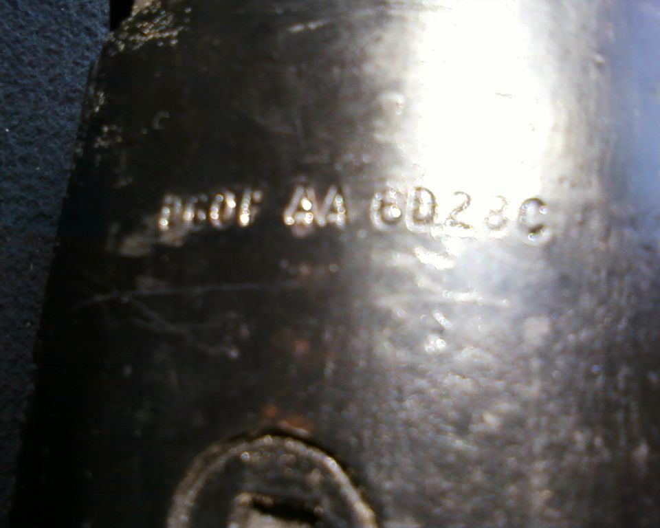 Close-up of a metal part showing stamped numbers: D6OF AA 6D23C