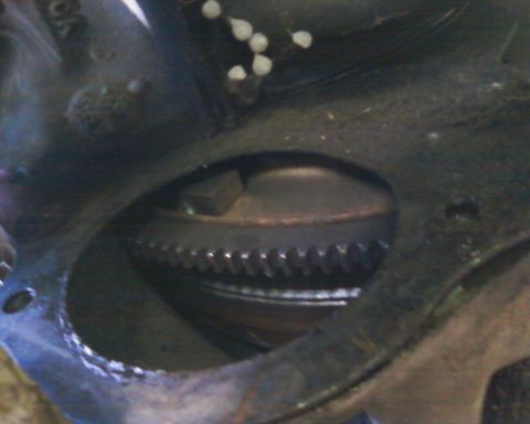 1976 Ford Torino - This image shows a close-up view of a starter motor and the teeth of a flywheel.