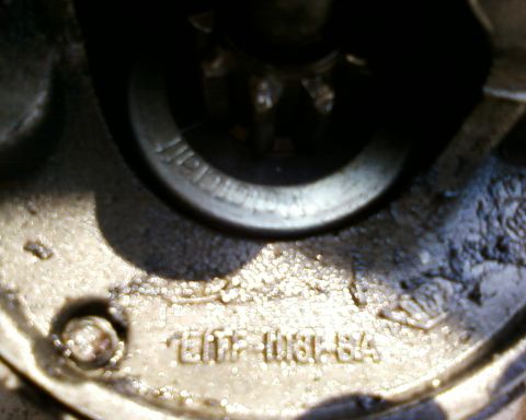 1976 Ford Torino - A close-up view of a metal component, possibly a starter motor, with visible markings and a gear.