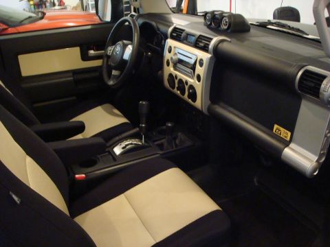 2010 Toyota FJ Cruiser - The interior of a Toyota FJ Cruiser is shown from the passenger side, highlighting the dashboard and seating.