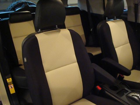 2010 Toyota FJ Cruiser - The interior of a vehicle features two-tone seats with beige and black upholstery, visible armrests, and a center console.