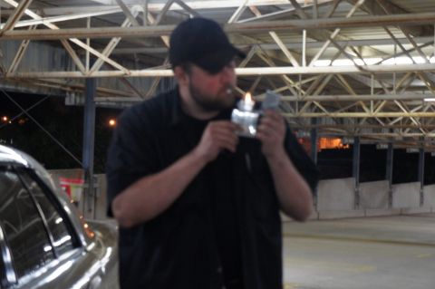 2000 Mercury Grand Marquis - Man lighting a cigarette in what appears to be a parking garage or industrial area.
