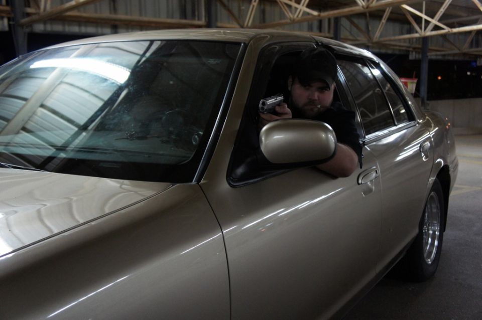 2000 Mercury Grand Marquis with man holding handgun out window