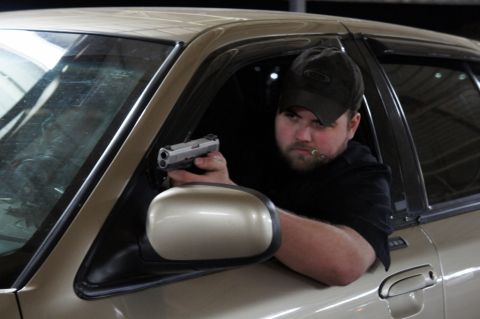 2000 Mercury Grand Marquis - A man with a gun and a cigar looks out of a car window.