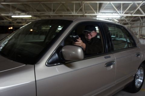 2000 Mercury Grand Marquis - Man with a handgun inside a tan 2000 Mercury Grand Marquis.