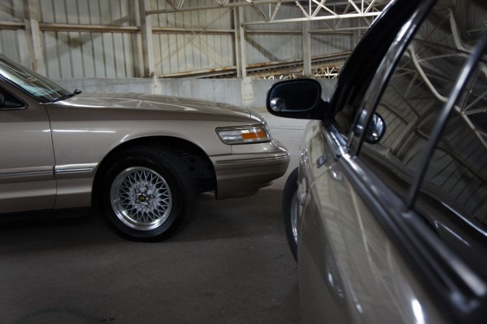 Tan sedan's front quarter panel and wheel, seen from the side