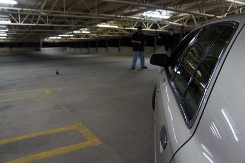 2000 Mercury Grand Marquis - A beige sedan is parked in a dimly lit, multi-level parking garage.