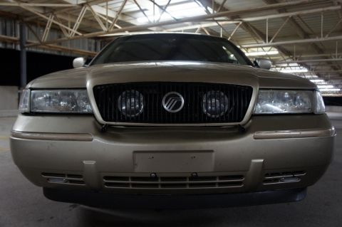 2000 Mercury Grand Marquis - Front view of a gold 2000 Mercury Grand Marquis parked indoors.