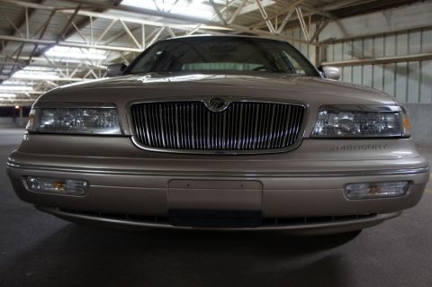 2000 Mercury Grand Marquis - The front grille and headlights of a Mercury Grand Marquis are visible in this indoor shot.