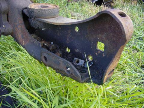 1992 Ford Bronco - A heavily rusted metal component rests on green grass, with a watermark indicating the source.