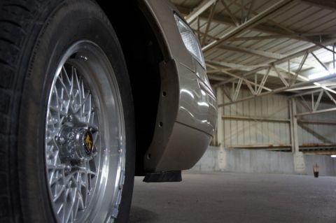 2000 Mercury Grand Marquis - Detail shot of a vehicle's fender and wheel, taken indoors with industrial ceiling visible.