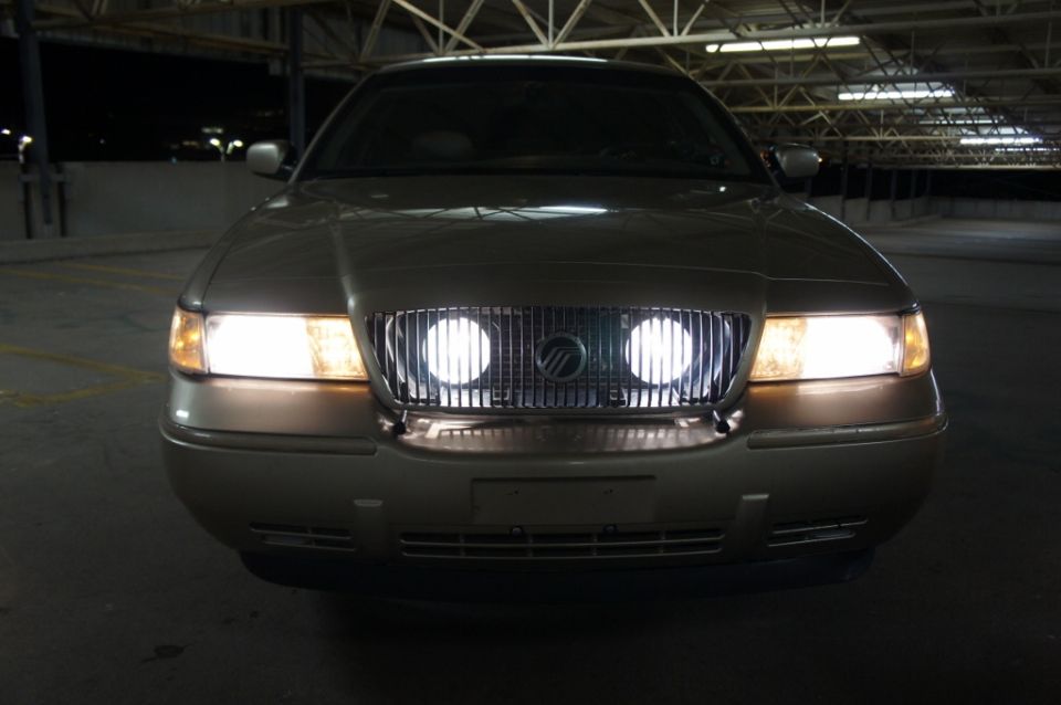 Gold Mercury Grand Marquis front view with headlights on