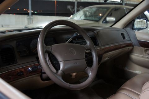 2000 Mercury Grand Marquis - The interior of a 2000 Mercury Grand Marquis is visible, with a second vehicle parked behind it.