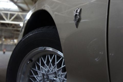 2000 Mercury Grand Marquis - A close-up shows a V8 badge on the fender of a beige car, with a wire wheel visible.