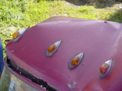 1992 Ford Bronco - The hood of a vehicle displays several amber marker lights, with visible damage near the windshield area.