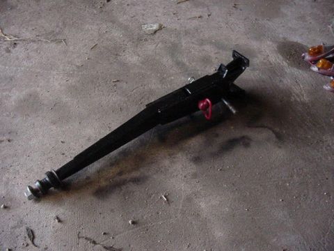 1992 Ford Bronco - A black metal jack with a red handle and threaded screw base rests on a concrete floor.