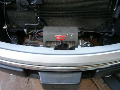 1995 Ford Bronco - A WARN winch is installed behind the front grille of a silver truck.