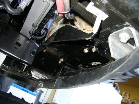 1995 Ford Bronco - Close-up of the undercarriage reveals various metal parts and fasteners, suggesting mechanical work or inspection.