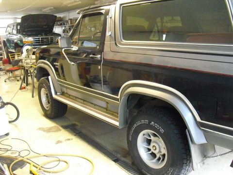 1996 Ford Bronco - A 1996 Ford Bronco is shown in a garage with another vehicle in the background.