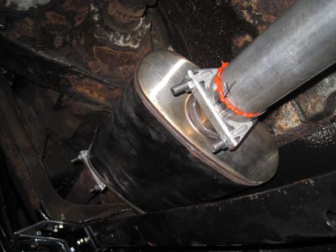 1979 Ford Bronco - Underside view of a vehicle's exhaust system, showing a new muffler and pipe connection.