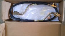 1985 Ford Bronco - Unused brake hose assembly with brass fittings, still in its original packaging.