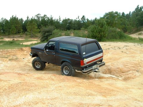 1995 Ford Bronco - This 1995 Ford Bronco navigates a sandy, off-road terrain with its tires.