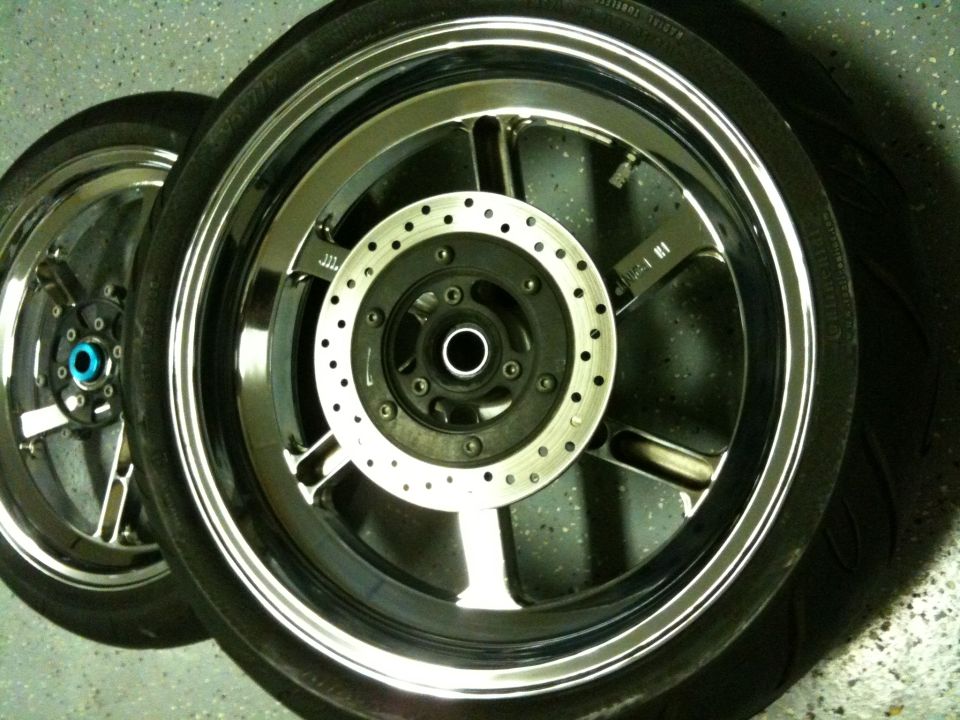 Two motorcycle wheels with chrome rims and disc brakes