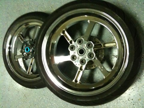 1996 Ford Bronco - Close-up of two motorcycle wheels, one in front of the other, showing their chrome finish and tire tread.