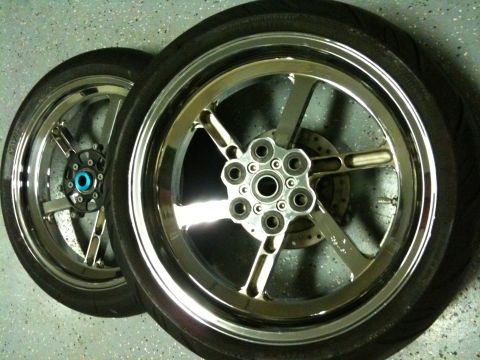 1996 Ford Bronco - Close-up view of two motorcycle wheels, one slightly behind the other, against a speckled gray background.