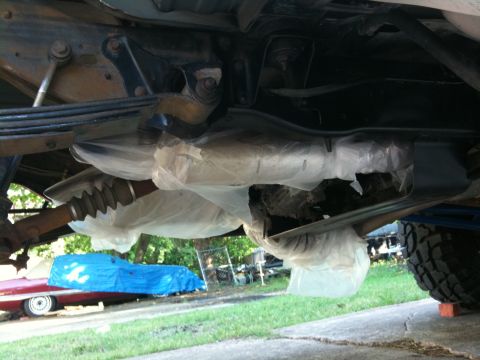 1996 Ford Bronco - The underside of a vehicle is shown, with another car partially visible in the background.