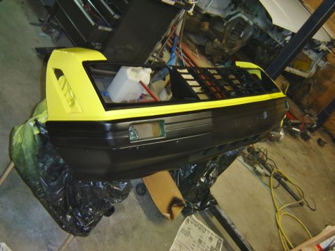 1979 Ford Mustang - A car's rear bumper assembly is shown in a workshop, partially covered in plastic sheeting.