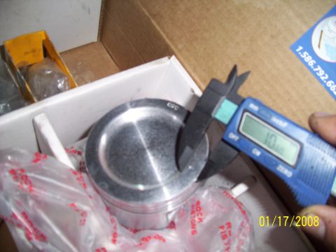 1995 Ford Probe - A piston is being measured with digital calipers, showing a reading of 10mm.