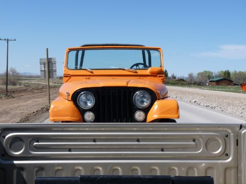 2006 Ford E350 - An orange Jeep CJ is viewed head-on from the perspective of a pickup truck bed.