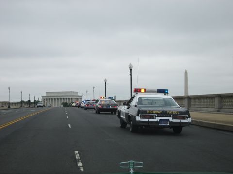 1991 Ford LTD Crown Victoria - black-and-white HIGHWAY PATROL car drives a bridge with the Lincoln Memorial and Washington Monument in the background.