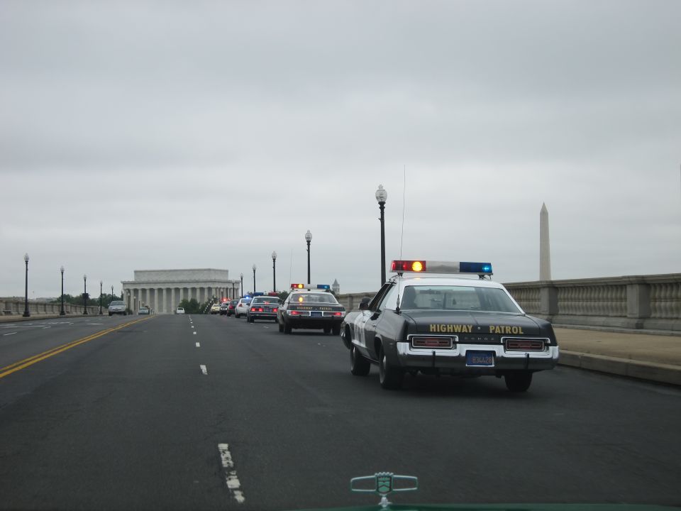 Highway Patrol car on a bridge with Lincoln Memorial and Washington Monument behind