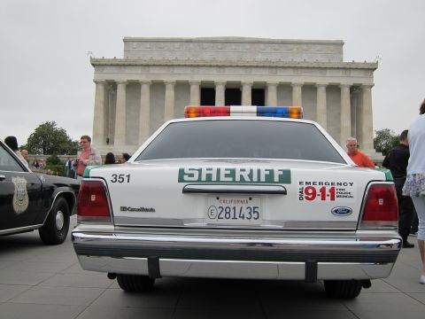 1991 Ford LTD Crown Victoria - rear of a white-and-green Ford Crown Victoria SHERIFF car with California plates sits before the Lincoln Memorial.