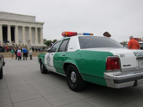 1991 Ford LTD Crown Victoria - white-and-green Ford Sheriff sedan numbered 351 is parked before the Lincoln Memorial as visitors walk nearby.