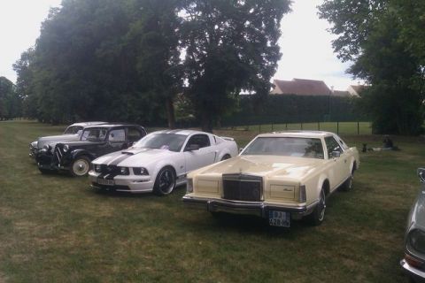 1991 Ford LTD Crown Victoria - A cream-colored 1979 Lincoln Continental Mark V is parked on a grassy field alongside other vehicles.